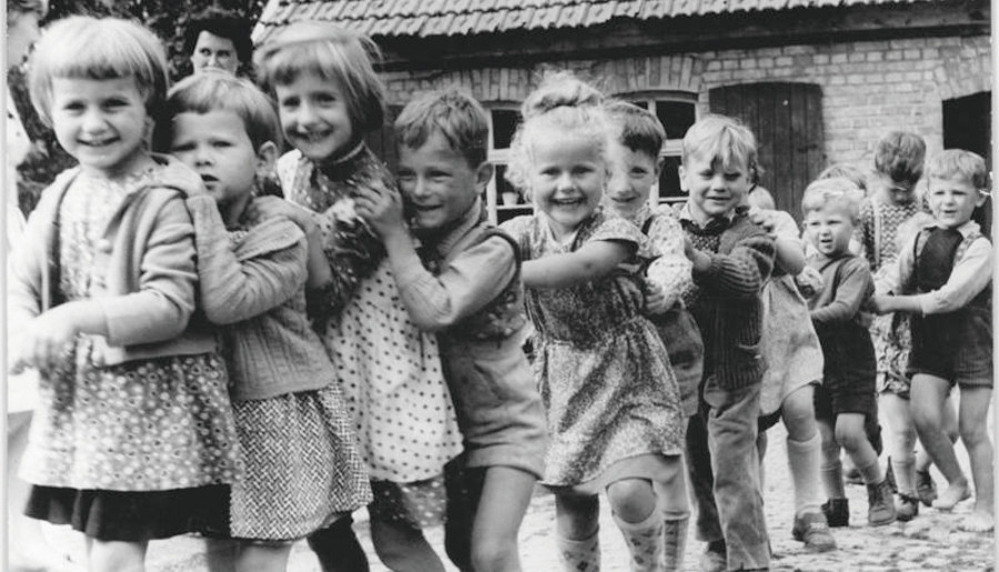 Altes Schwarz-Weiß Bild einer Gruppe lachender Kinder.